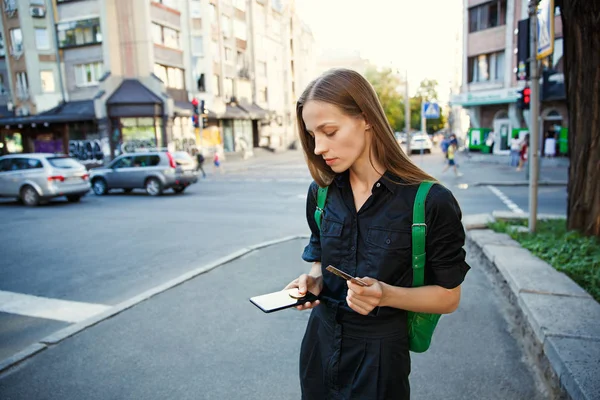 コイン Bitcoin と古い街の背景に手でスマート フォンを持つ若い女性 — ストック写真