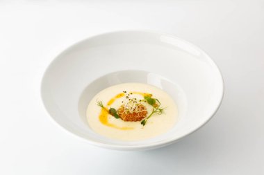 büyük bir beyaz tabak beyaz arka plan üzerinde izole yeşillik ile krem çorba