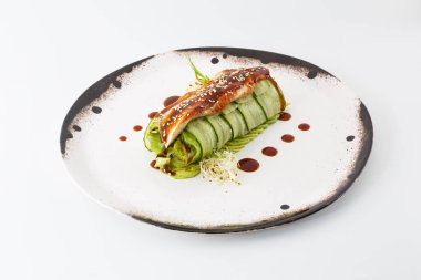 Salatalık salatası izole beyaz arka plan üzerinde beyaz bir tabak içinde sivilce ile rulo.