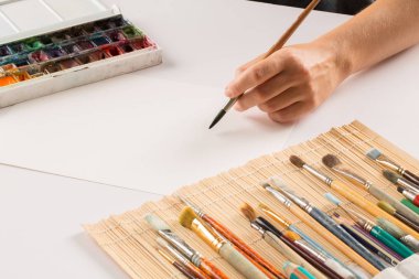 bir fırça ile el Beyaz Kağıt arka planda çizer