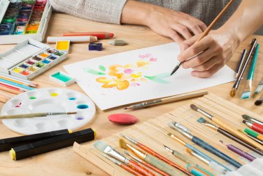 bir fırça ile el bir beyaz kağıt arka planda brushe arasında çizer