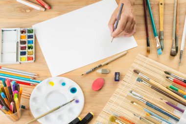 bir fırça ile el bir beyaz kağıt arka planda brushe arasında çizer