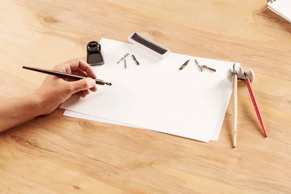 ink writing set with notepad and pen on wooden background