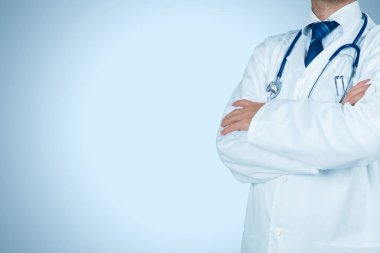 Üzerinde mavi arka plan ayakta pratisyen doktor 