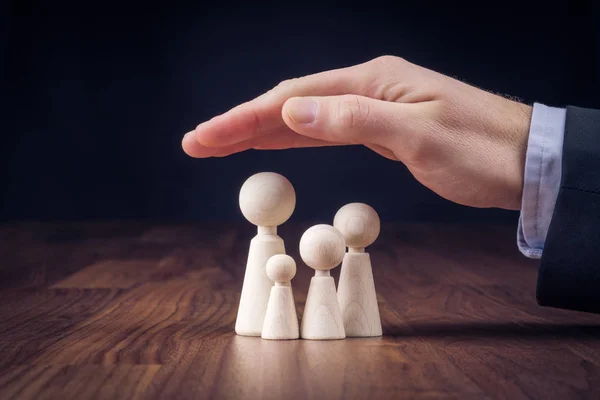 Businessman Protective Gesture Wooden Figurines Representing Young Insured Family — Stock Photo, Image