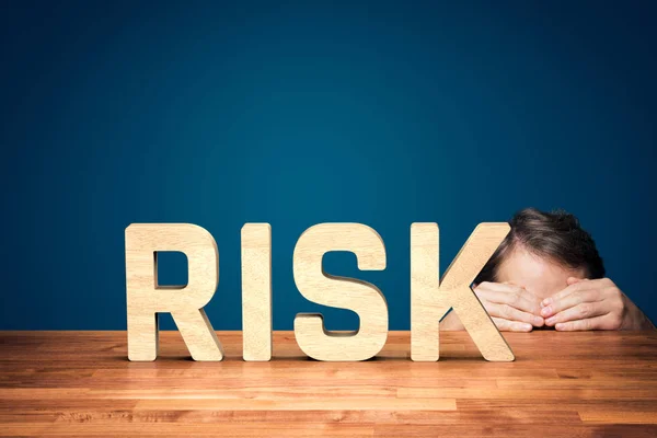 风险管理者害怕企业中的风险 担心或胆小的商人躲在桌子后面 防范商业风险 — 图库照片
