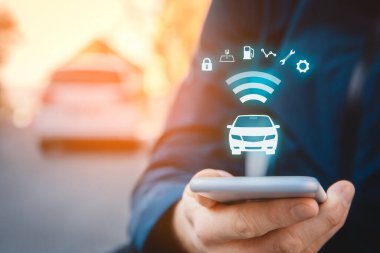 Akıllı telefon konsepti, akıllı araç konsepti ve akıllı araba konsepti üzerine akıllı araba uygulaması. Sokakta akıllı telefonu olan biri, arka planda arabası ve arabayla kablosuz iletişimi olan biri..
