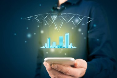 Akıllı (akıllı) şehir konsepti - haberleşme teknolojisi (ICT) ve internet teknolojisi (IoT) şehir varlıklarını yönetmek için entegre edildi. Akıllı telefonu olan, şehir sembolü ve kablosuz iletişimi olan kişi.
