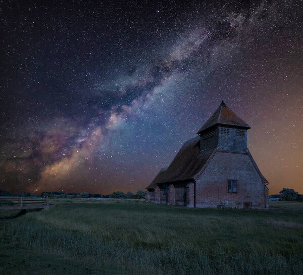 Stunning vibrant Milky Way composite image over landscape of Ancient Medieval church
