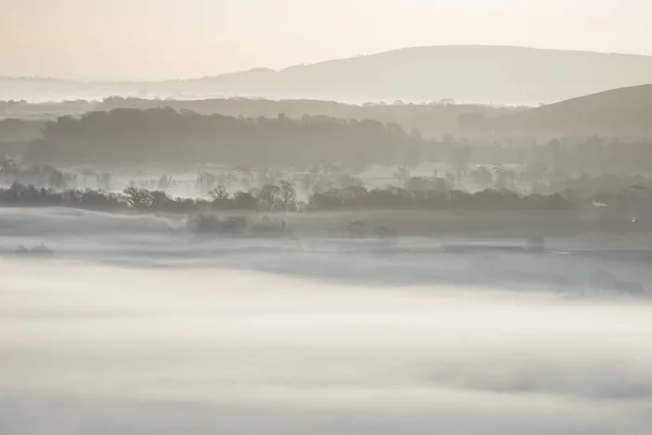 霧の美しい田園風景レイヤーのフィールドを圧延の冬の日の出 — ストック写真