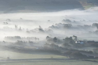 Güzel sisli İngilizce kırsal peyzaj alanları üzerinden haddeleme katmanları ile kışın gündoğumu