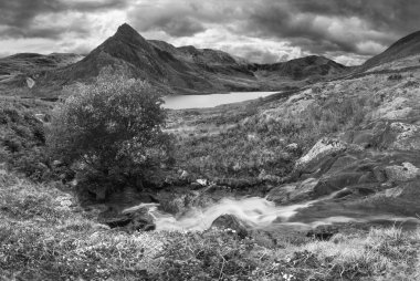 Siyah ve beyaz güzel panorama manzara resim Llyn Ogwen Snowdonia içinde yakınındaki kayaların üzerinden Tryfan ile erken sonbahar sırasında arka planda akan dere