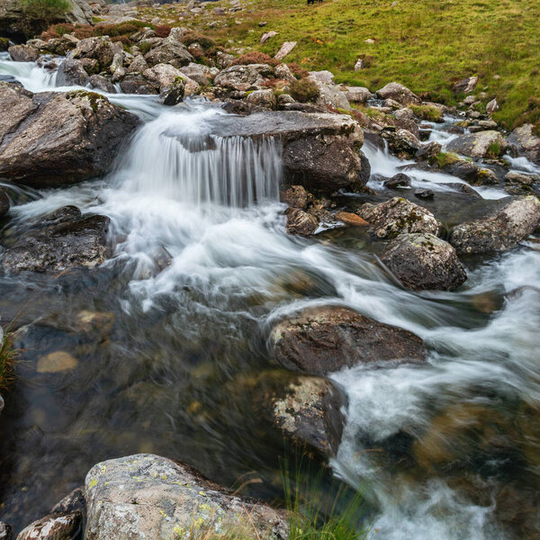 Landscape image of river flowing down mountain range near Llyn Ogwen and Llyn Idwal in Snowdonia in Autumn