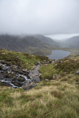 Moody manzara suretinde Llyn Idwal Glyders dağ aralığında ağır yağış sonbaharda Snowdonia içinde