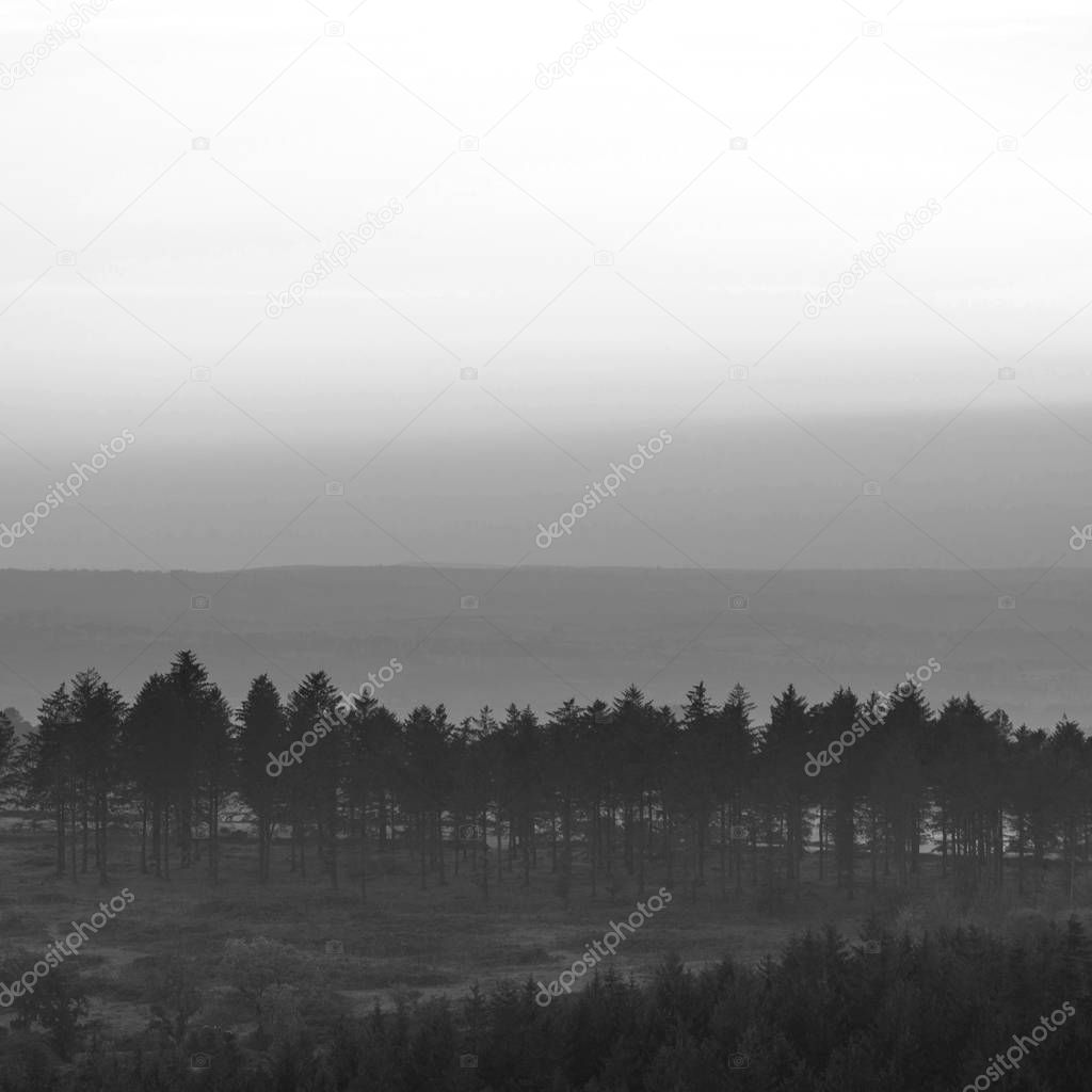 Beautiful Autumn sunset landscape image of view from Leather Tor in Dartmoor National Park in black and white
