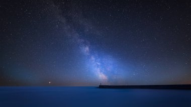 Stunning vibrant Milky Way composite image over landscape of Stunning long exposure of lighthouse clipart