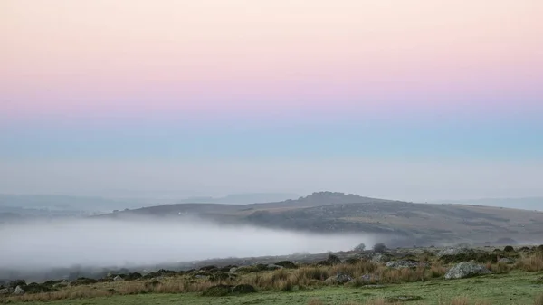 Wspaniałe Wschód Mglisty Krajobraz Tors Dartmoor Odsłoniętych Peaks Przez Mgłę — Zdjęcie stockowe