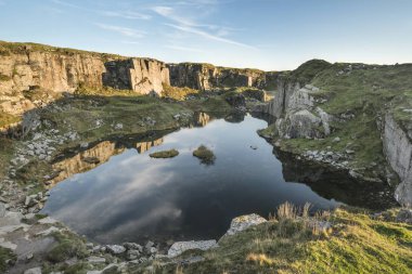 Güzel manzara günbatımı resmin üzerine Dartmoor terk edilmiş Foggintor ocağında yumuşak güneş ışığı harap ve terk edilmiş binalar üzerinde yan yatan ile