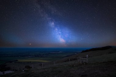 Stunning vibrant Milky Way composite image over landscape of countryside in Summer clipart