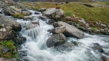 Sonbaharda Llyn Ogwen ve Snowdonia Llyn Idwal yakınındaki dağ aralığı aşağı akan nehir manzara görüntüsü