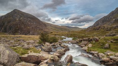 Sonbaharda Llyn Ogwen ve Snowdonia Llyn Idwal yakınındaki dağ aralığı aşağı akan nehir manzara görüntüsü