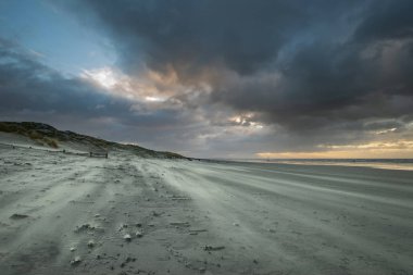 Güzel kış gündoğumu Sussex İngiltere'de Batı Wittering plaj kum plaj esen rüzgar ile üzerinde