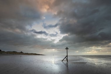 Güzel kış gündoğumu Sussex İngiltere'de Batı Wittering plaj kum plaj esen rüzgar ile üzerinde