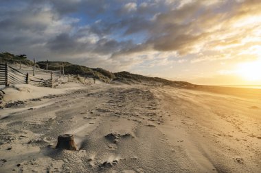 Güzel kış gündoğumu Sussex İngiltere'de Batı Wittering plaj kum plaj esen rüzgar ile üzerinde