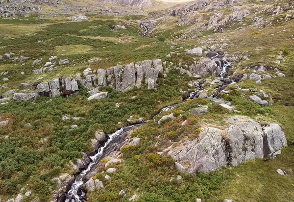 スノードニアで滝の上下岩の上を流れる川の空撮風景をドローンします — ストック写真