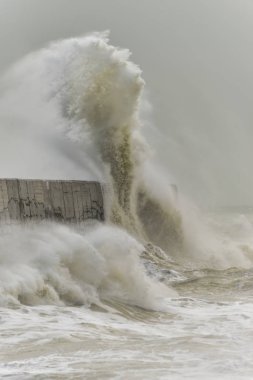 Stunning waves crashing over harbor wall during windy storm at Newhaven on English coast clipart
