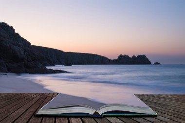 Güzel renkli gündoğumu manzara görüntü sihirli hikaye kitabı sayfalarında çıkan İngiltere'de Güney Cornwall sahilindeki Porthcurno Beach