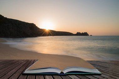 Güzel renkli gündoğumu manzara görüntü sihirli hikaye kitabı sayfalarında çıkan İngiltere'de Güney Cornwall sahilindeki Porthcurno Beach