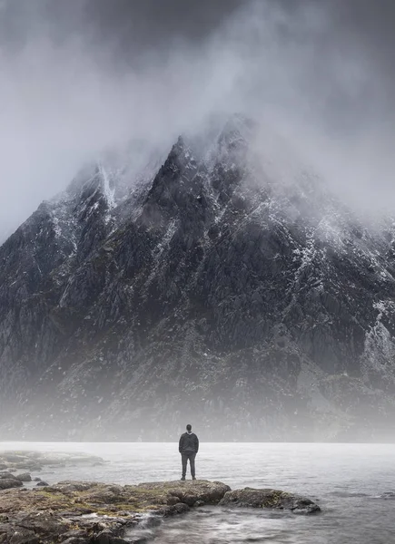 人站在雾蒙的山前，给规模蒙 — 图库照片