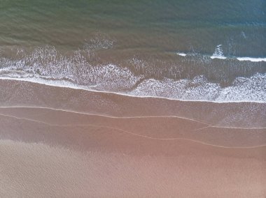 Boea'da yavaşça yuvarlanan sakin dalgaların canlı yukarıdan aşağıya drone görünümü