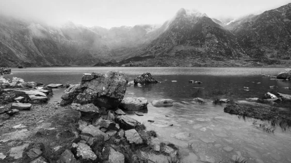 Piękny nastrojowy zimowy krajobraz wizerunek Llyn Idwal i Snowcap — Zdjęcie stockowe