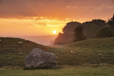 Stunning Summer sunrise landscape of Neolithic standing stones i clipart