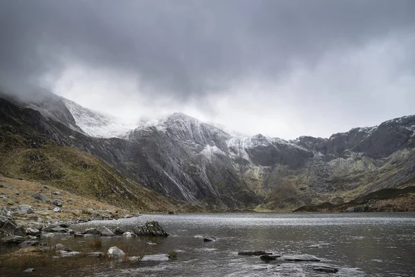 Beautiful moody Winter landscape image of Llyn Idwal and snowcap — Stock Photo, Image