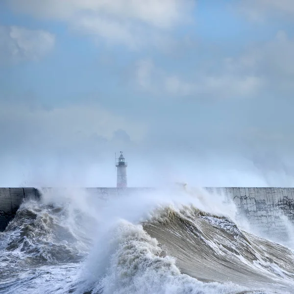 Huge waves crash over harbour wall onto lighthouse during huge storm on English coastline in Newhaven, amazing images showing power of the ocean
