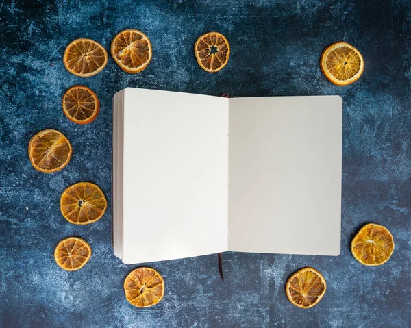 Offene Buchseiten Umgeben Von Getrockneten Orangenscheiben Auf Texturiertem Blauem Vintage — Stockfoto