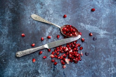 Yırtık Nar meyvesi ve tohumlarının düz görünümü pürüzlü arka planda yatıyordu