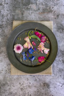 Düz bir şekilde uzanmış çiçek yapraklarının romantik mahsul görüntüsünün kırsal ve yıpranmış arka planında hayat devam ediyor.