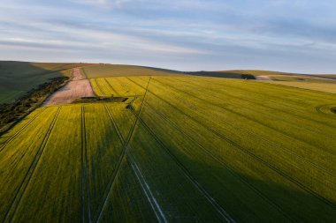 Güzel yüksek uçan drone manzarası İngiliz kırsalındaki yuvarlanan tepelerin hoş sıcak ışıklarıyla