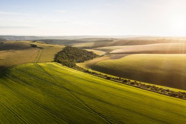 Güzel yüksek uçan drone manzarası İngiliz kırsalındaki yuvarlanan tepelerin hoş sıcak ışıklarıyla