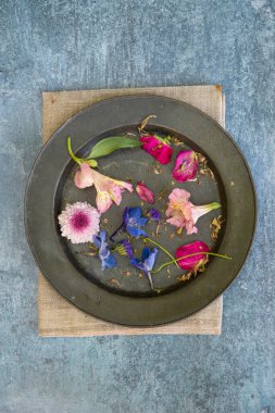 Düz bir şekilde uzanmış çiçek yapraklarının romantik mahsul görüntüsünün kırsal ve yıpranmış arka planında hayat devam ediyor.