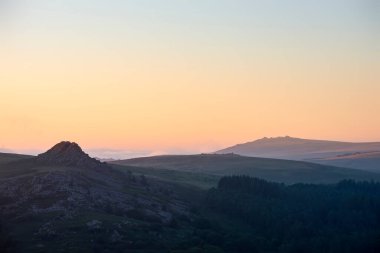 İngiltere 'deki Dartmoor' un Deri Tor ve Kings Tor 'u destansı gündoğumu ışığında gösteren muhteşem manzara.