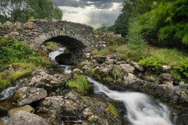 İngiliz Lake District 'teki Ashness Köprüsü' nün güzel uzun pozlu manzarası yaz öğleden sonra karamsar havayla birlikte.