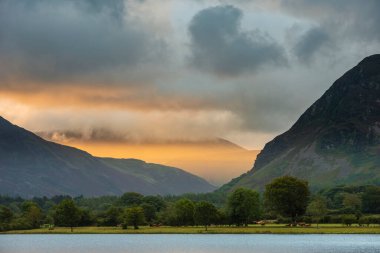 Loweswater boyunca Lkae Bölgesi 'ndeki Grasmoor ve Mellbreak dağlarındaki muhteşem ışığa bakan güzel bir gündoğumu manzarası.