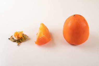 Beyaz arka plan üzerinde bütünleşmiş, kesme ve bitmiş Trabzon hurması adet