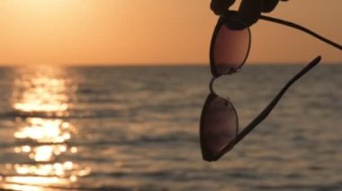 Kadın eli gözlük, bir arka plan mavi deniz suyu tutar.