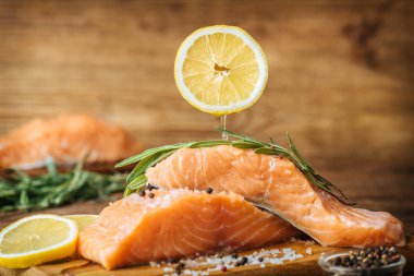 Ahşap arka plan üzerinde çiğ Somon Balık fileto üzerine limon suyu damlar.